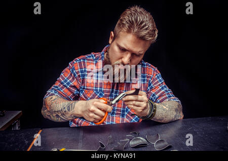 Leather Worker produces leather workpiece at the studio Stock Photo