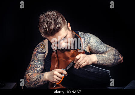 Currier creates quality product of leather at his leather studio Stock Photo