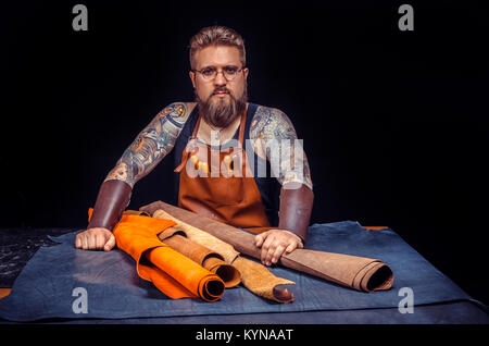 Currier processes a workpiece from leather at the workplace Stock Photo