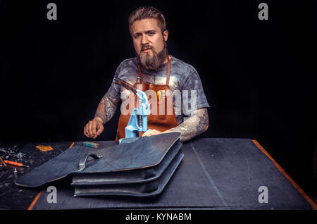 Skinner processing a leather workpiece Stock Photo