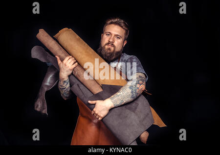 Leather Artisan creating a new leather product in the leather shop Stock Photo