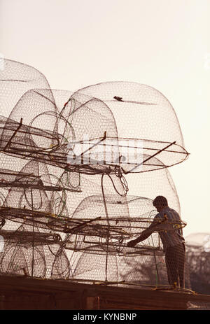 Fisherman prepares fishing nets and loads onto Dhow boat at Al Ruwais, a fishing port in Northern Qatar. Stock Photo