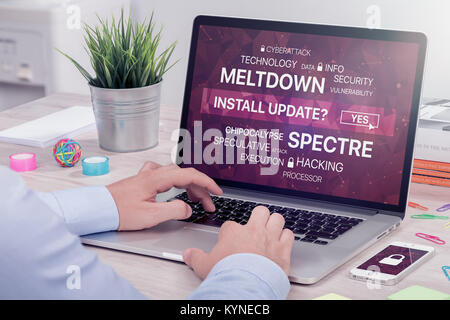Installing update against meltdown and spectre threat on laptop in office space. Stock Photo