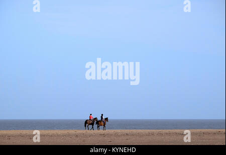 horse riders on holkham beach, north norfolk, england Stock Photo