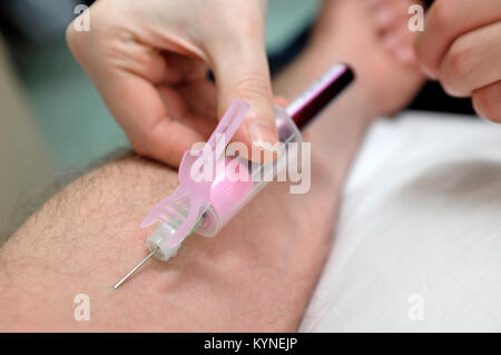 taking blood sample from male arm Stock Photo