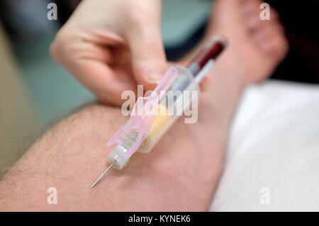 taking blood sample from male arm Stock Photo