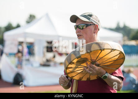During the partial phase of the total solar eclipse on August 21, 2017, a man drums in Madras, Oregon. The total eclipse was visible along a narrow path across the U.S., with partial views in other regions of North America, South America, Africa, and Europe. Stock Photo