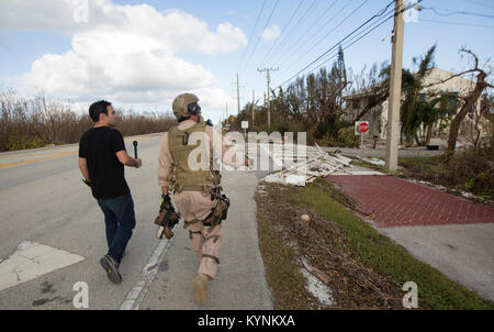 U.S. Customs and Border Protection Air and Marine Operations Aviation Enforcement Agent Mickey Hohol, right,   walks with weather reporter Dave Malkoff of the Weather Channel as they look over the damage at Cudjoe Key to survey the damage done by the eye of Hurricane Irma September 12, 2017. U.S. Customs and Border Protection photo by Glenn Fawcett Stock Photo