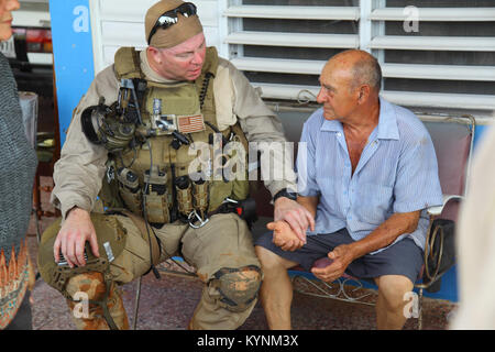 An Air and Marine Operations EMT tends to a elderly gentlemen at a home on a mountain top in central Puerto Rico on Sunday September 24 after putting out a SOS on the homes roof. Stock Photo