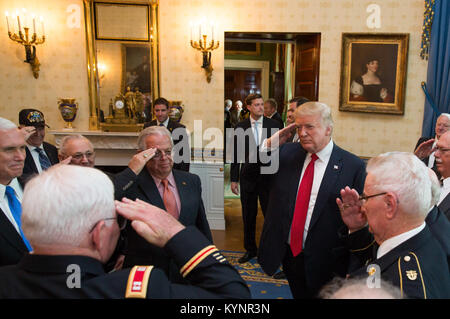 President Donald J. Trump, joined by Vice President Mike Pence, left, salutes Medal of Honor recipient retired U.S. Army Capt. Gary M. Rose, and fellow Vietnam veteran “Battle Buddies”, in the Blue Room at the White House in Washington, D.C. | October 23, 2017 (Official White House Photo by Joyce N. Boghosian) November 2017 National Veterans and Military Families Month 38678542982 o Stock Photo