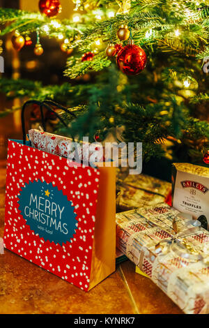 BUCHAREST, ROMANIA - DECEMBER 24, 2017: Presents And Chocolate Candies Waiting To Be Opened Under Christmas Tree Stock Photo