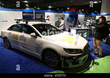 Detroit, USA. 14th Jan, 2018. A man takes photos of a car at a booth of University of Michigan during the press preview of the 2018 North American International Auto Show (NAIAS) in Detroit, the United States, on Jan. 14, 2018. The 2018 NAIAS exhibits 40 automobile companies introducing over 20 new cars. Credit: Wang Ping/Xinhua/Alamy Live News Stock Photo