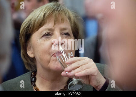 Trinwillershagen, Germany. 12th Jan, 2018. German Chancellor Angela Merkel (CDU) drinks during the New Year's Reception of the state counsil of the district Vorpommern-Ruegen in Trinwillershagen, Germany, 12 January 2018. Merkel has been representing the electoral district Stralsund-Greifswald-Ruegen-Vorpommern since 1990 in the German Bundestag with a direct mandate. Credit: Stefan Sauer/dpa/Alamy Live News Stock Photo