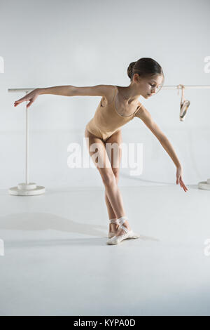 The girl is training near the ballet barre. Stock Photo