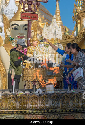 Worshippers pour water over Buddha statue, Shwedagon Pagoda, Yangon, Myanmar (Burma) Stock Photo