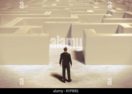 toy miniature businessman figurine entering a  white maze structure Stock Photo