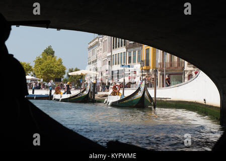 AVEIRO, PORTUGAL - AUG 21, 2017: Moliceiro boats sail along the central canal in Aveiro, Portugal. Image taken from a 'moliceiro' while we were under  Stock Photo