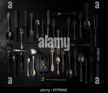 https://l450v.alamy.com/450v/kypwwc/big-set-of-vintage-cutlery-with-smartphote-over-black-metal-background-kypwwc.jpg
