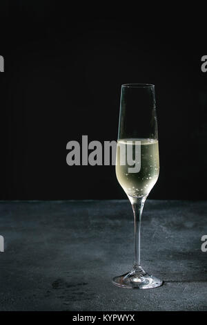 One glass of white champagne over dark texture background. Copy space Stock Photo