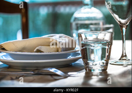 Elegant table set for dinning in a summer with white porcelain dishes, white vintage lace napkin and glassware Stock Photo