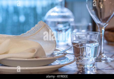 Elegant table set for dinning in a summer with white porcelain dishes, white vintage lace napkin and glassware Stock Photo