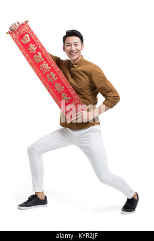 Cheerful young man with couplet celebrating Chinese new year Stock Photo