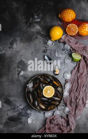 top view of delicious mussels with shells on vintage plate and citrus fruits with ice cubes on grey   Stock Photo