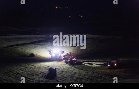 Farmer wrapping bales of silage at night in the dark. UK Stock Photo