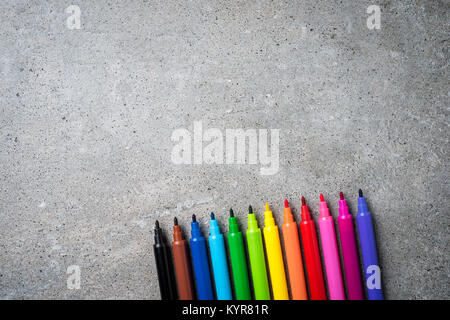 Overhead shot of colorful markers on gray stone table. Close up Stock Photo
