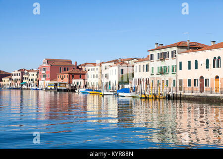 Reflections of colorful buildings on a canal, Murano Island, Venice,  Veneto, Italy in winter sunshine Stock Photo