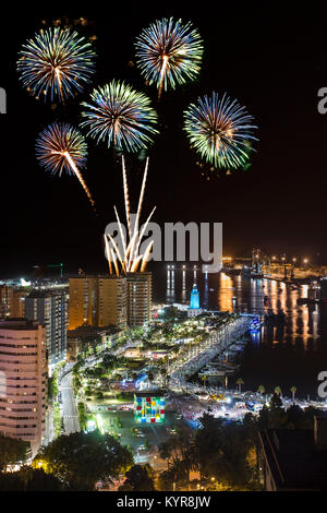 Picturesque view of bright fireworks exploding above colorful glowing Malaga city in night Stock Photo