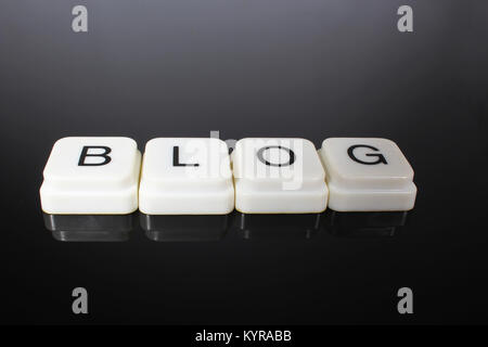 Blog text word title caption label cover backdrop background. Alphabet letter toy blocks on black reflective background. White alphabetical letters. White educational toy block with words on mirror table. Stock Photo