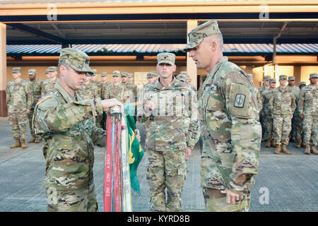 Capt. Edgar Conrad and 1st Sgt. James Rutherford, 58th Military Police Company, 728th Military Police Battalion, 8th Military Police Brigade, uncase the unit guidon at Schofield Barracks, Hawaii, following a six-month deployment to Anderson Air Force Base, Guam on January 10, 2018. (U.S. Army Stock Photo