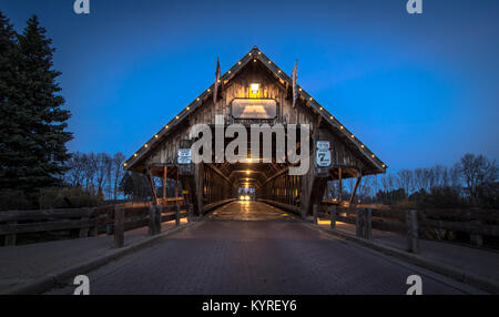 Michigan Covered Bridge. Car entering historic covered bridge illuminated at night in Frankenmuth Michigan Stock Photo