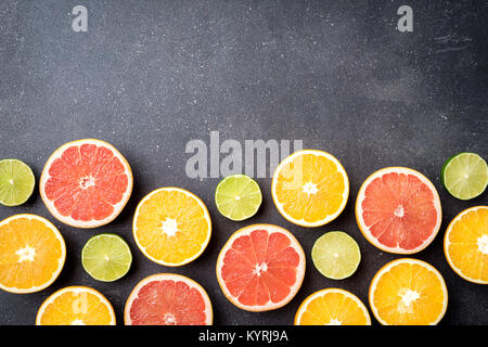 Half of citrus fruits on dark stone background Stock Photo