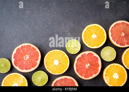 Half of citrus fruits on dark stone background Stock Photo