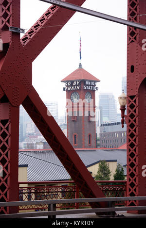 Tower of the train station in Portland with a clock and flag through the farms of Broadway Bridge on Willamette River Stock Photo