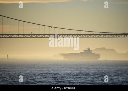 Container ship NYK Constellation leaves San Francisco Bay under the Golden Gate Bridge into the sunset.