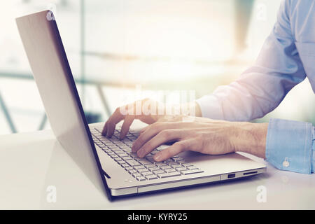 modern businessman working on laptop in bright sunny office Stock Photo