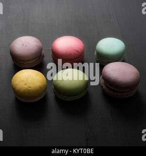 multicolored macaroon on a dark wooden table, from above Stock Photo