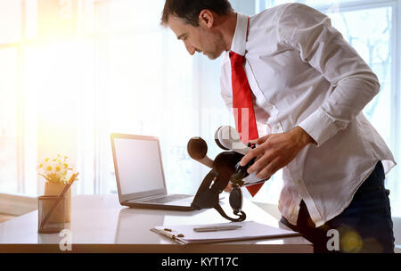 Office worker standing working with virtual reality glasses and computer in the office. Horizontal composition. Stock Photo