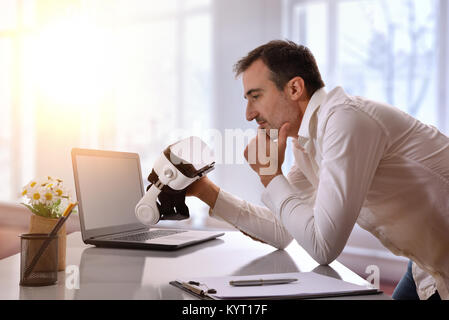 Office worker working looking at virtual reality glasses in the office. Horizontal composition. Stock Photo