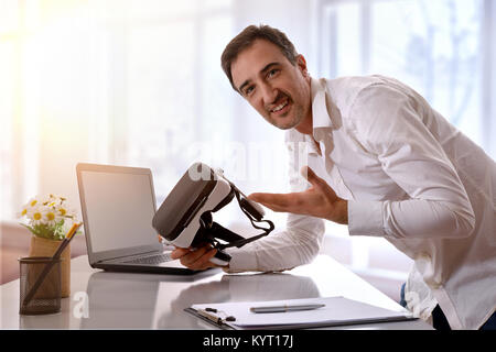 Office worker working showing virtual reality glasses in the office.. Horizontal composition. Stock Photo