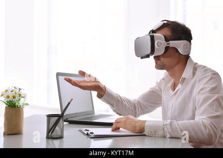 Office worker interacting with virtual reality glasses in the office. Horizontal composition. Stock Photo