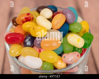 close up of multicoloured jelly beans in a glass on a wooden background Stock Photo