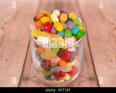 multicoloured jelly beans in a glass on a wooden background Stock Photo