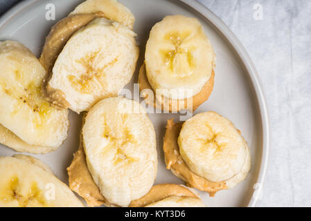 Light Healthy Snack made from Banana Slices and Cashew Butter, on Grey Background Stock Photo