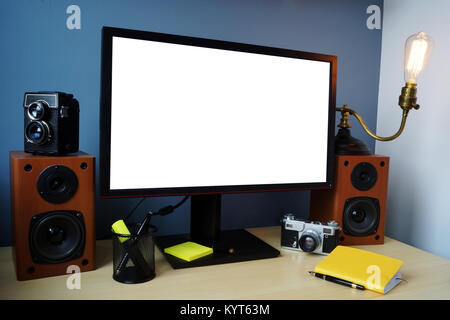 Stylish workspace with monitor, vintage camera and lamp and office supplies. Mock-up. Stock Photo