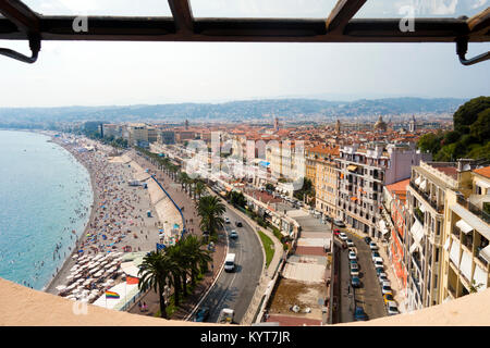 Amazing tourists bird's-eye viewpoint overlooking blue Mediterranean sea beach with palm trees and bright colorful city of Nice France on sunny day Stock Photo