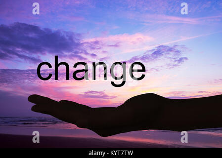 Hand offering the word change, sunset background Stock Photo